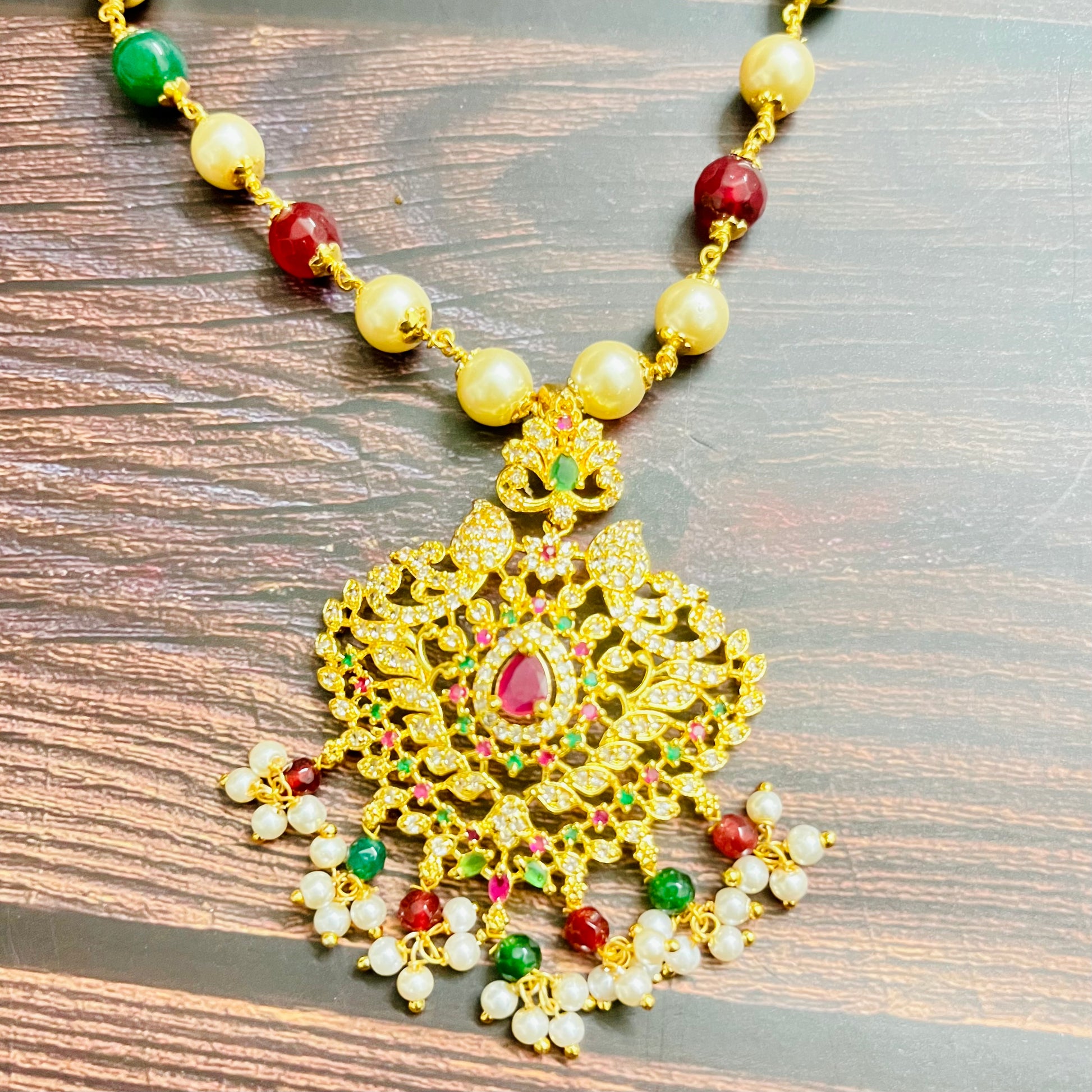 traditional necklace, temple jewelry, Indian bridal jewelry, handmade necklace, festive jewelry, gold-plated pendant, statement jewelry, pearl necklace, ruby green necklace, ethnic jewelry, South Indian jewelry, kundan choker, designer necklace, party wear jewelry, bridal set, imitation jewelry, boutique collection, ethnic wear look, wedding collection, elegant Indian necklace