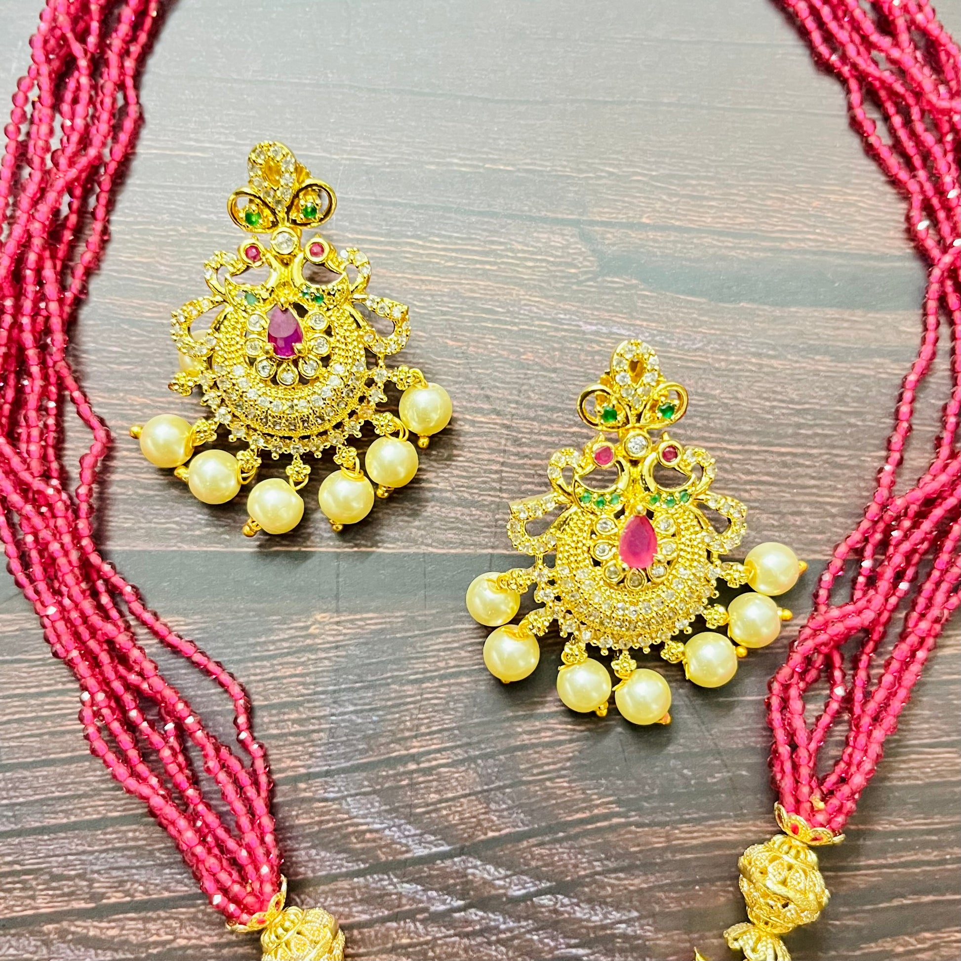 traditional jewelry, temple jewelry, bridal necklace, pearl necklace, ethnic wear, gold plated jewelry, South Indian jewelry, handcrafted jewelry, festive wear, statement necklace, antique finish, Indian bride, designer jewelry, heavy necklace set, wedding collection, navratna stones, ruby emerald combo, temple earrings, kundan work, goddess jewelry, mangalsutra look, cultural heritage, pink thread necklace, handmade jewelry, fashion accessories