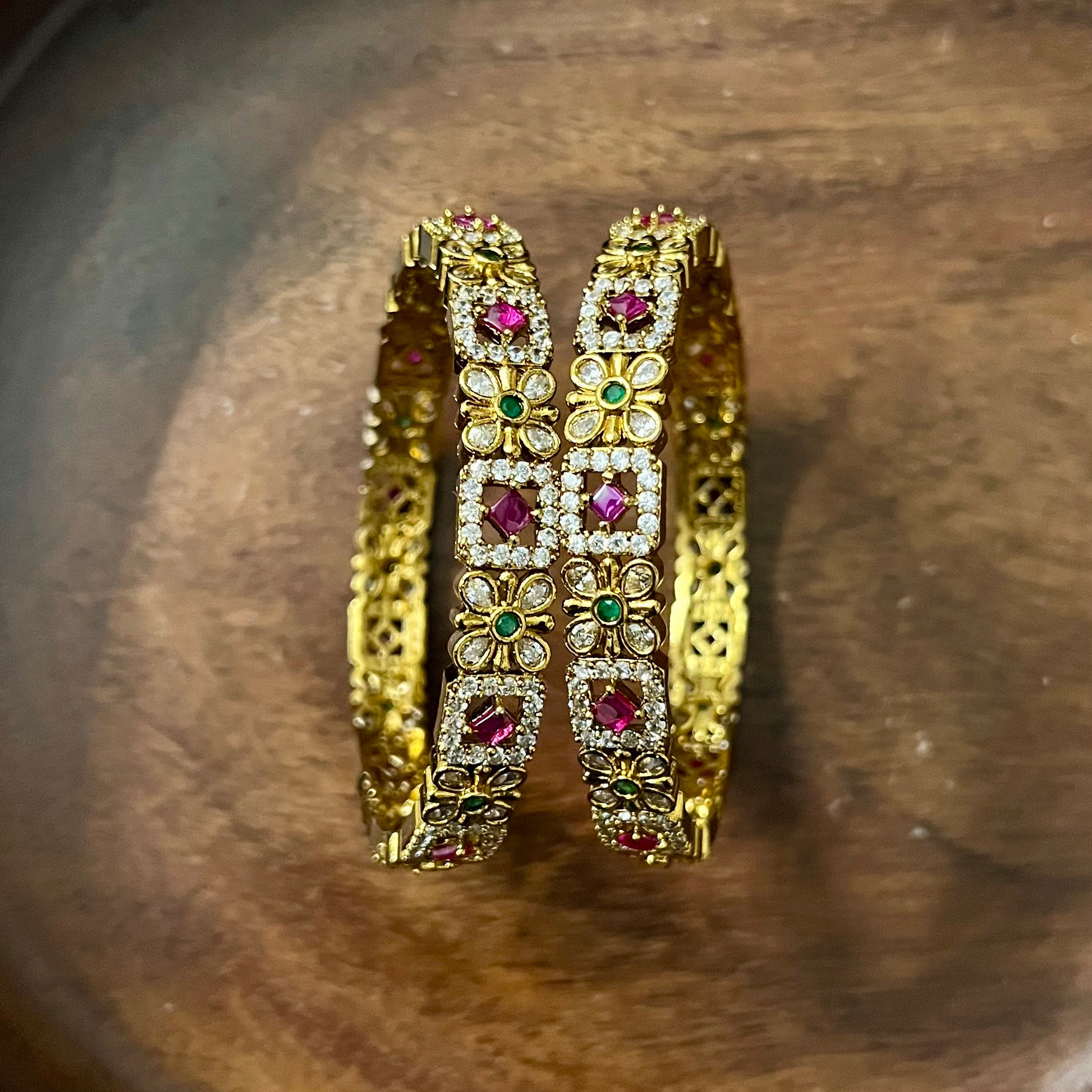 floral bangles, gold tone bangles, ruby stone bangles, emerald bangles, traditional bangles, Indian bangles, designer bangles, festive jewelry, wedding bangles, bridal bangles, ethnic jewelry, imitation bangles, kundan style bangles, party wear bangles, temple jewelry, handmade bangles, statement bangles, pushpa valli bangles, Indian accessories, South Indian jewelry