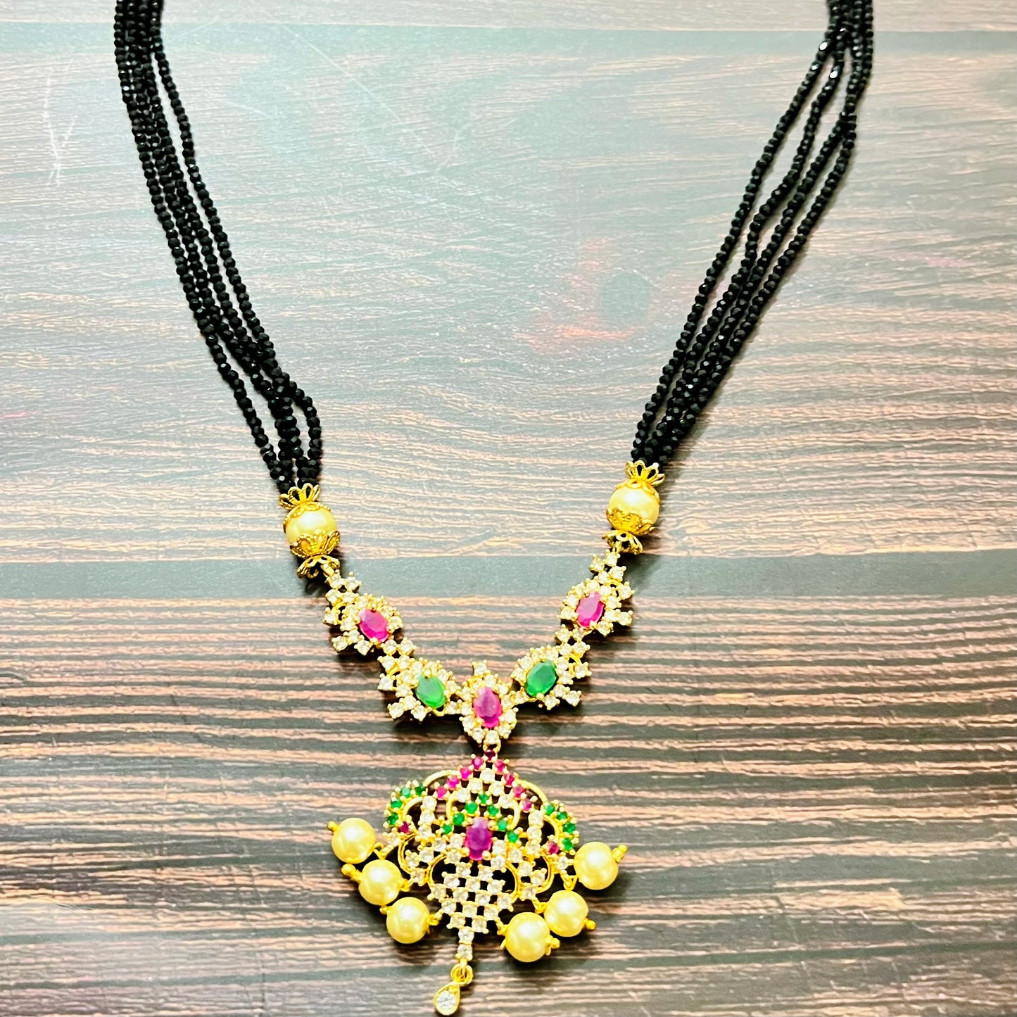 mangalsutra, bridal mangalsutra, pearl jewelry, traditional jewelry, gold plated, black beads necklace, Indian wedding, gemstone jewelry, emerald necklace, ruby necklace, designer mangalsutra, ethnic jewelry, south Indian jewelry, bridal accessories, handmade jewelry, temple jewelry, marriage mangalsutra, gold jewelry, multi-strand mangalsutra, heritage jewelry, festive jewelry, Indian bride, statement necklace, antique style, classic mangalsutra