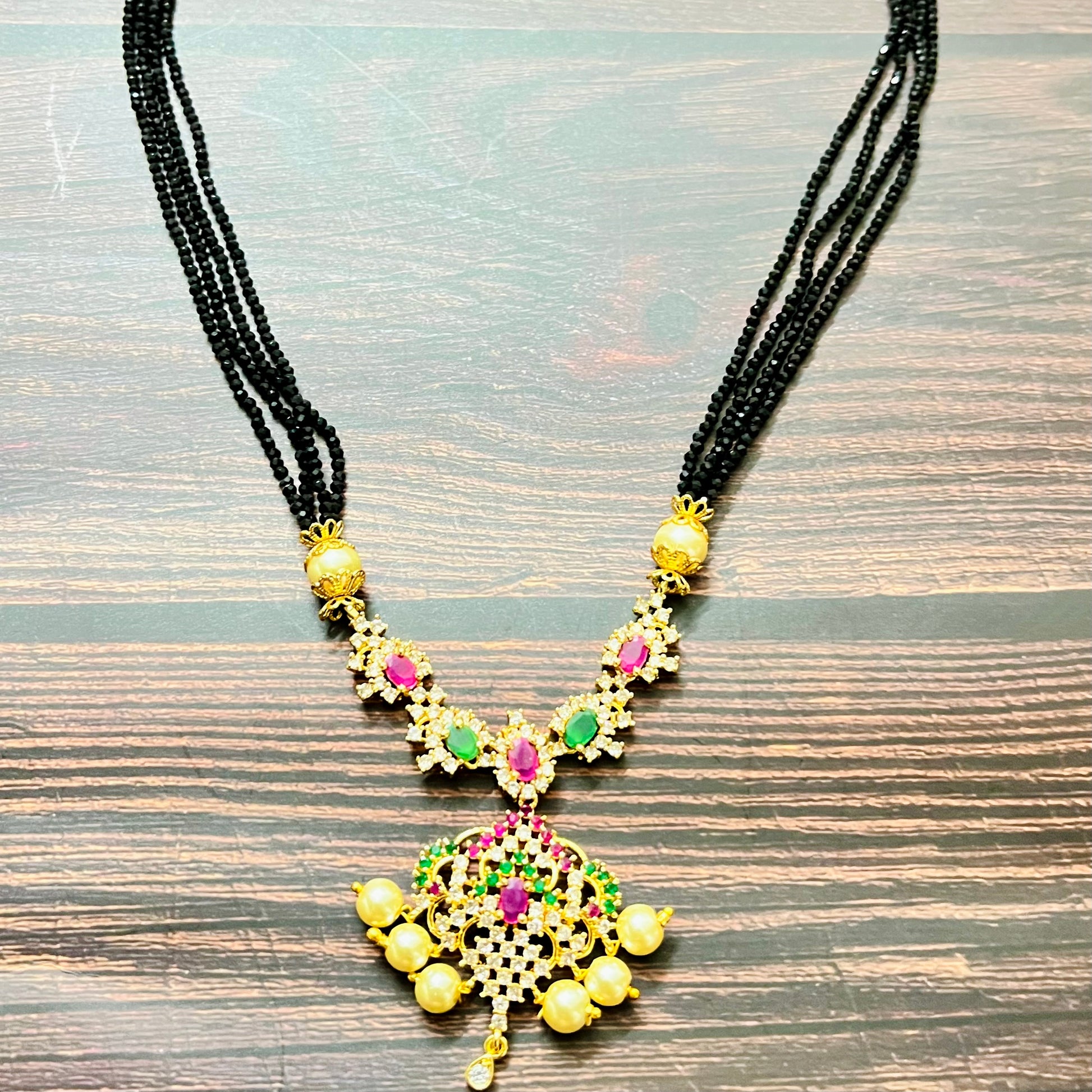 mangalsutra, bridal mangalsutra, pearl jewelry, traditional jewelry, gold plated, black beads necklace, Indian wedding, gemstone jewelry, emerald necklace, ruby necklace, designer mangalsutra, ethnic jewelry, south Indian jewelry, bridal accessories, handmade jewelry, temple jewelry, marriage mangalsutra, gold jewelry, multi-strand mangalsutra, heritage jewelry, festive jewelry, Indian bride, statement necklace, antique style, classic mangalsutra