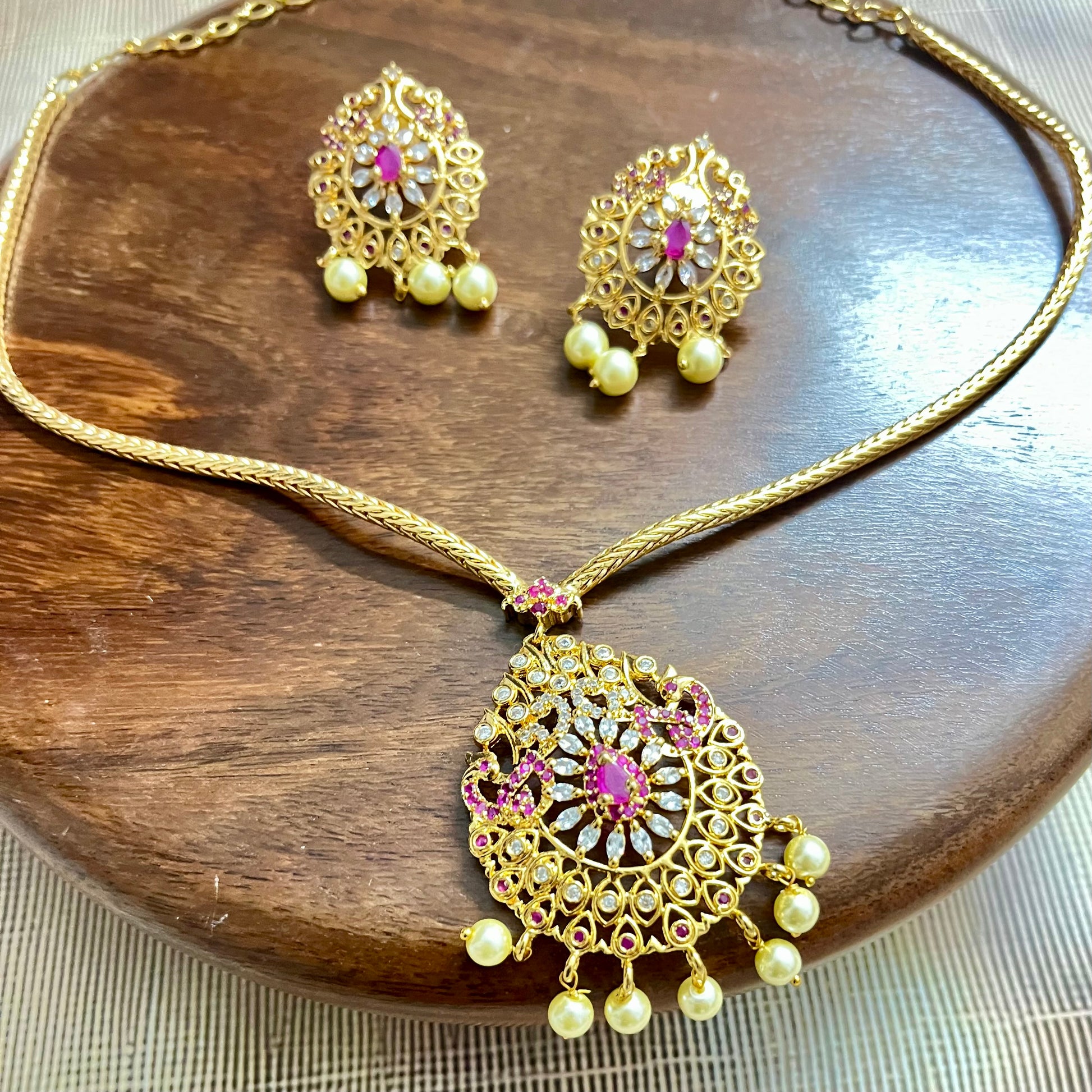 gold-plated jewelry set, necklace and earring set, traditional Indian jewelry, ruby stone necklace, pearl drop earrings, bridal jewelry set, ethnic jewelry, wedding jewelry, festive jewelry, antique finish necklace, Indian necklace set, kundan style jewelry, temple jewelry set, handcrafted jewelry, party wear necklace, designer jewelry set, red and gold jewelry, floral design necklace, imitation jewelry set, ethnic wear accessories