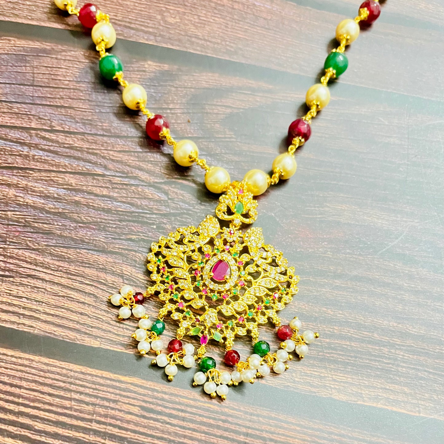 traditional necklace, temple jewelry, Indian bridal jewelry, handmade necklace, festive jewelry, gold-plated pendant, statement jewelry, pearl necklace, ruby green necklace, ethnic jewelry, South Indian jewelry, kundan choker, designer necklace, party wear jewelry, bridal set, imitation jewelry, boutique collection, ethnic wear look, wedding collection, elegant Indian necklace