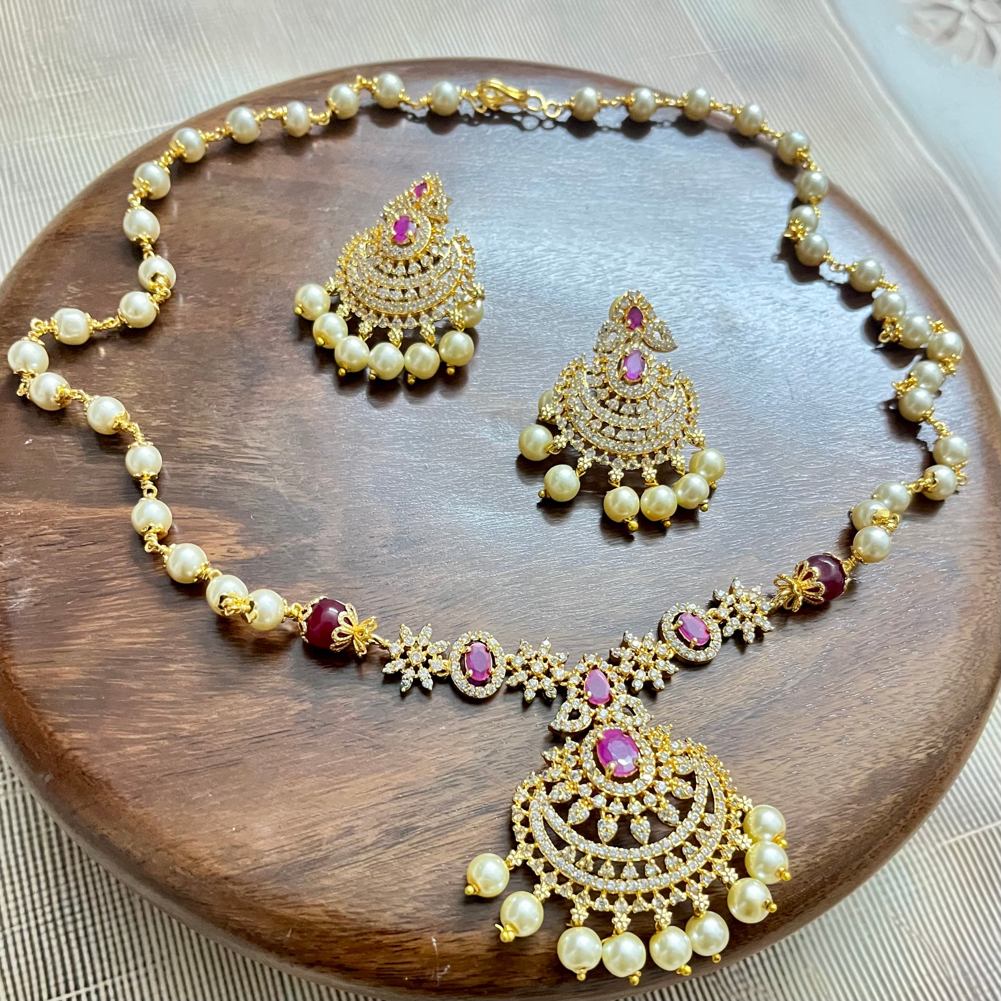 traditional jewelry set, pearl necklace set, ruby stone jewelry, gold tone necklace, bridal jewelry set, Indian jewelry, ethnic necklace, wedding jewelry, festive jewelry, pearl and ruby set, designer necklace set, kundan style jewelry, South Indian jewelry, statement necklace, handcrafted jewelry, imitation jewelry, choker necklace set, temple jewelry style, elegant jewelry set, party wear jewelry