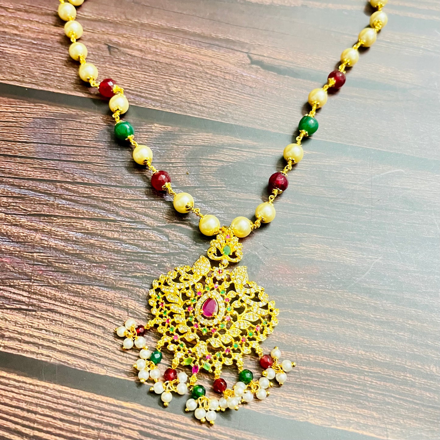 traditional necklace, temple jewelry, Indian bridal jewelry, handmade necklace, festive jewelry, gold-plated pendant, statement jewelry, pearl necklace, ruby green necklace, ethnic jewelry, South Indian jewelry, kundan choker, designer necklace, party wear jewelry, bridal set, imitation jewelry, boutique collection, ethnic wear look, wedding collection, elegant Indian necklace