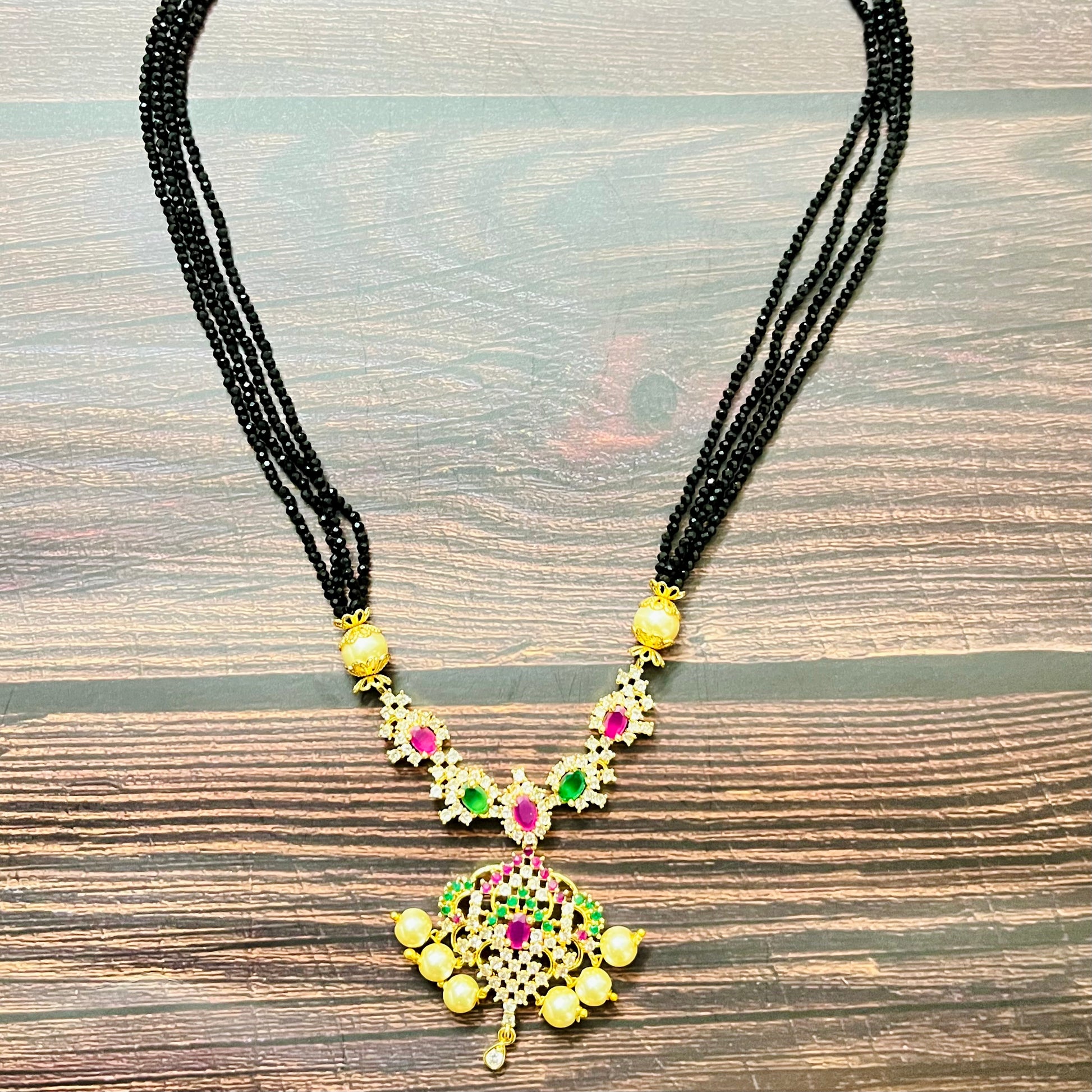 mangalsutra, bridal mangalsutra, pearl jewelry, traditional jewelry, gold plated, black beads necklace, Indian wedding, gemstone jewelry, emerald necklace, ruby necklace, designer mangalsutra, ethnic jewelry, south Indian jewelry, bridal accessories, handmade jewelry, temple jewelry, marriage mangalsutra, gold jewelry, multi-strand mangalsutra, heritage jewelry, festive jewelry, Indian bride, statement necklace, antique style, classic mangalsutra