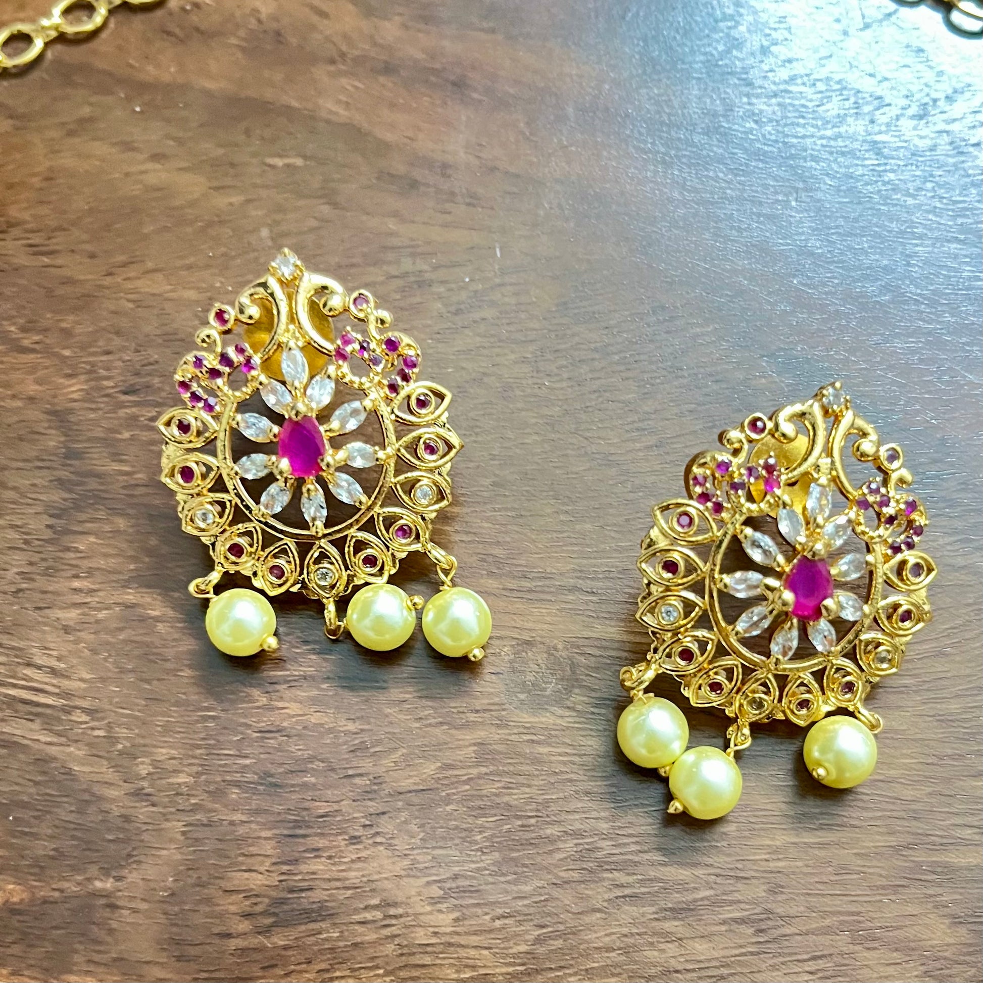 gold-plated jewelry set, necklace and earring set, traditional Indian jewelry, ruby stone necklace, pearl drop earrings, bridal jewelry set, ethnic jewelry, wedding jewelry, festive jewelry, antique finish necklace, Indian necklace set, kundan style jewelry, temple jewelry set, handcrafted jewelry, party wear necklace, designer jewelry set, red and gold jewelry, floral design necklace, imitation jewelry set, ethnic wear accessories