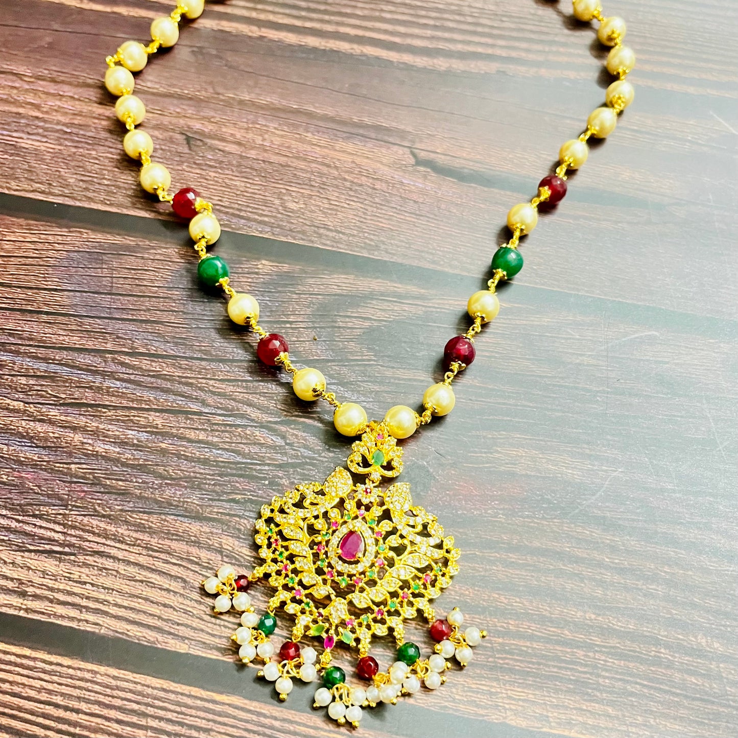 traditional necklace, temple jewelry, Indian bridal jewelry, handmade necklace, festive jewelry, gold-plated pendant, statement jewelry, pearl necklace, ruby green necklace, ethnic jewelry, South Indian jewelry, kundan choker, designer necklace, party wear jewelry, bridal set, imitation jewelry, boutique collection, ethnic wear look, wedding collection, elegant Indian necklace