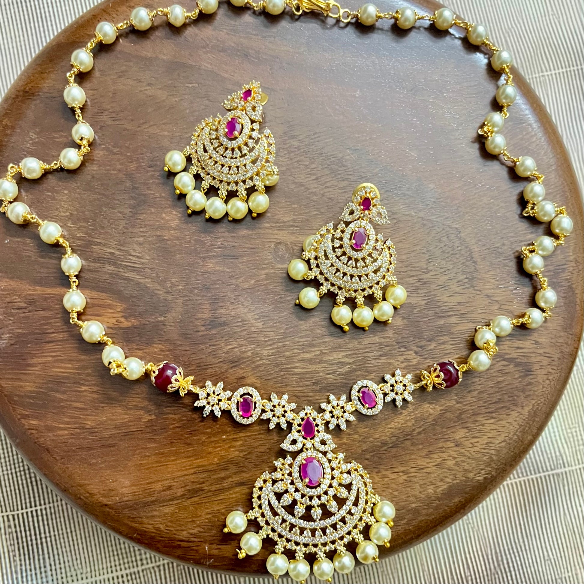 traditional jewelry set, pearl necklace set, ruby stone jewelry, gold tone necklace, bridal jewelry set, Indian jewelry, ethnic necklace, wedding jewelry, festive jewelry, pearl and ruby set, designer necklace set, kundan style jewelry, South Indian jewelry, statement necklace, handcrafted jewelry, imitation jewelry, choker necklace set, temple jewelry style, elegant jewelry set, party wear jewelry