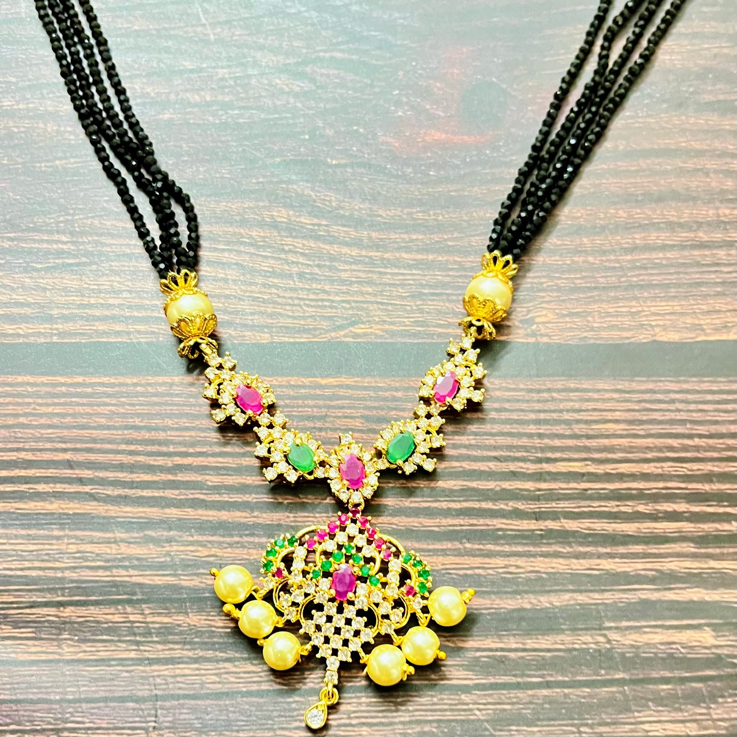 mangalsutra, bridal mangalsutra, pearl jewelry, traditional jewelry, gold plated, black beads necklace, Indian wedding, gemstone jewelry, emerald necklace, ruby necklace, designer mangalsutra, ethnic jewelry, south Indian jewelry, bridal accessories, handmade jewelry, temple jewelry, marriage mangalsutra, gold jewelry, multi-strand mangalsutra, heritage jewelry, festive jewelry, Indian bride, statement necklace, antique style, classic mangalsutra