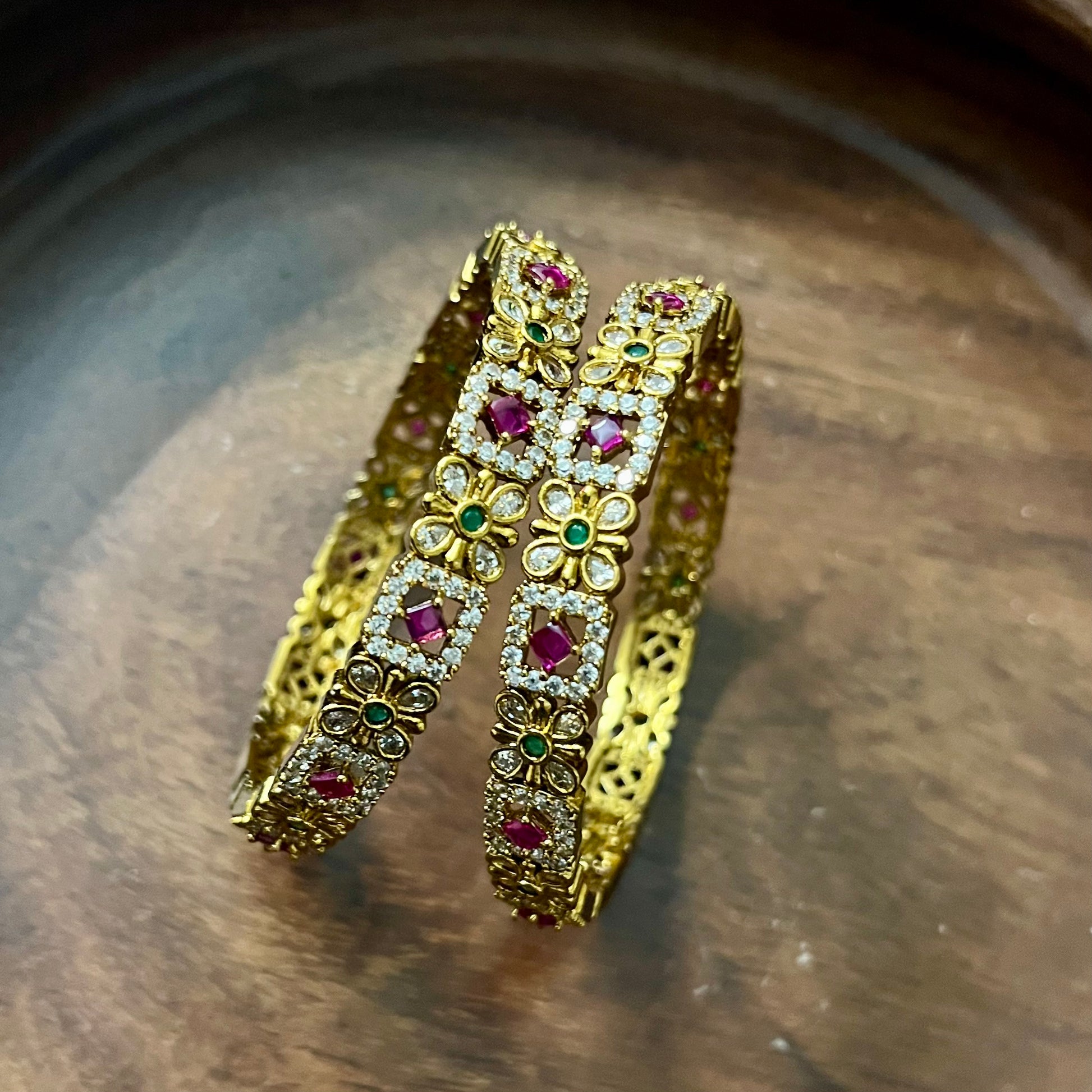 floral bangles, gold tone bangles, ruby stone bangles, emerald bangles, traditional bangles, Indian bangles, designer bangles, festive jewelry, wedding bangles, bridal bangles, ethnic jewelry, imitation bangles, kundan style bangles, party wear bangles, temple jewelry, handmade bangles, statement bangles, pushpa valli bangles, Indian accessories, South Indian jewelry
