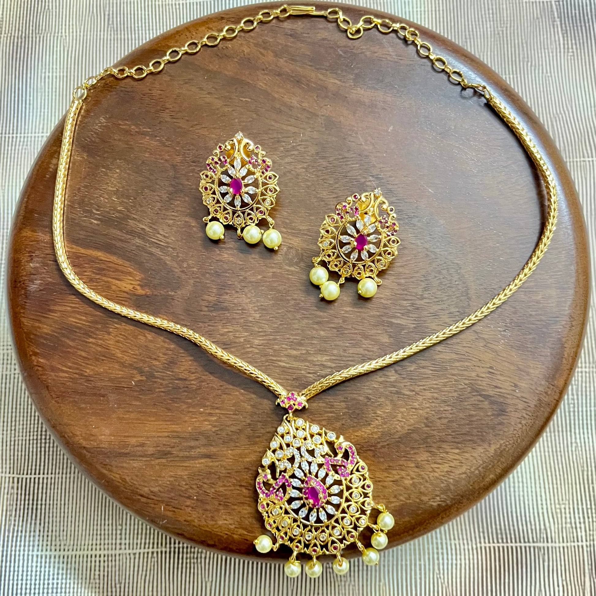 gold-plated jewelry set, necklace and earring set, traditional Indian jewelry, ruby stone necklace, pearl drop earrings, bridal jewelry set, ethnic jewelry, wedding jewelry, festive jewelry, antique finish necklace, Indian necklace set, kundan style jewelry, temple jewelry set, handcrafted jewelry, party wear necklace, designer jewelry set, red and gold jewelry, floral design necklace, imitation jewelry set, ethnic wear accessories