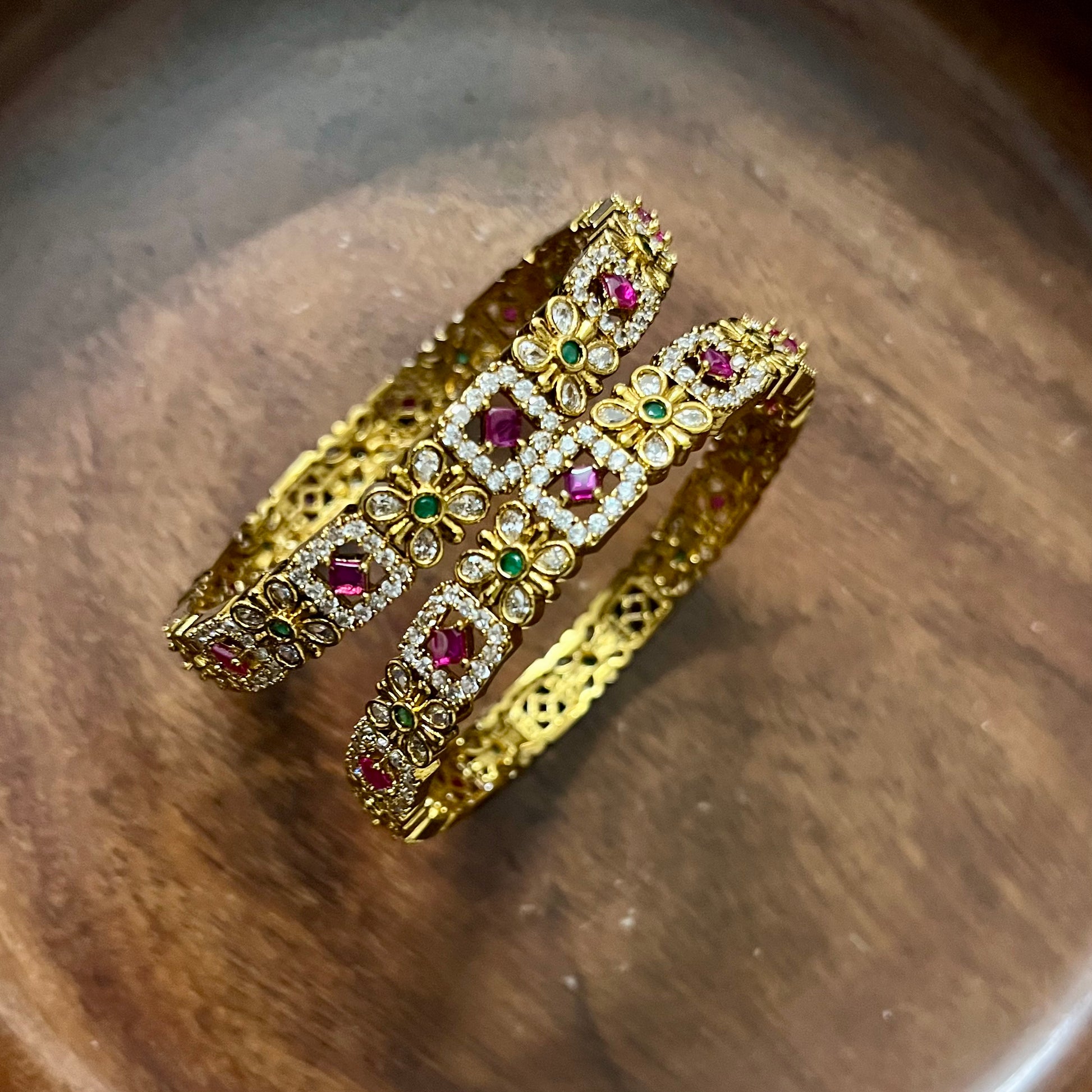 floral bangles, gold tone bangles, ruby stone bangles, emerald bangles, traditional bangles, Indian bangles, designer bangles, festive jewelry, wedding bangles, bridal bangles, ethnic jewelry, imitation bangles, kundan style bangles, party wear bangles, temple jewelry, handmade bangles, statement bangles, pushpa valli bangles, Indian accessories, South Indian jewelry