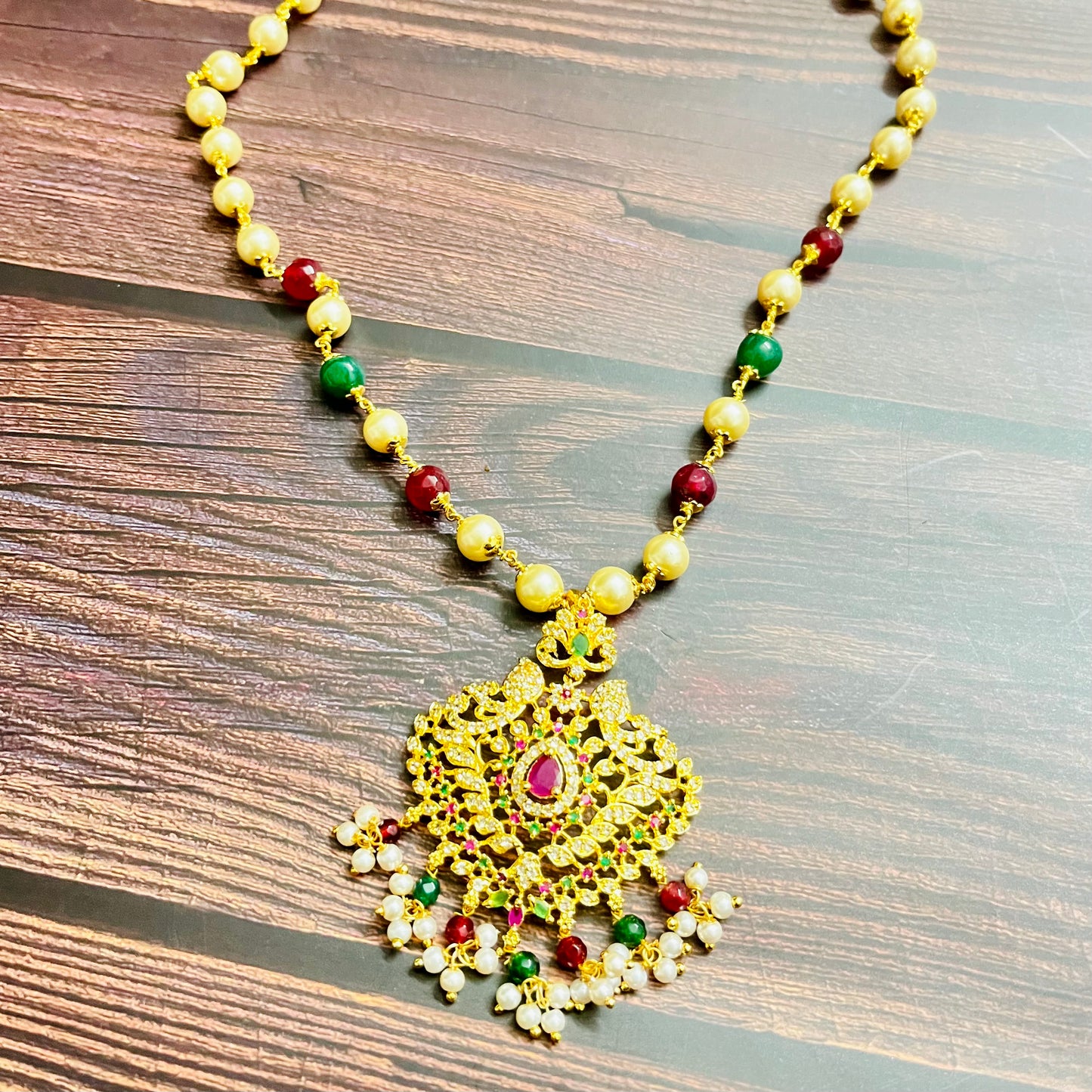 traditional necklace, temple jewelry, Indian bridal jewelry, handmade necklace, festive jewelry, gold-plated pendant, statement jewelry, pearl necklace, ruby green necklace, ethnic jewelry, South Indian jewelry, kundan choker, designer necklace, party wear jewelry, bridal set, imitation jewelry, boutique collection, ethnic wear look, wedding collection, elegant Indian necklace