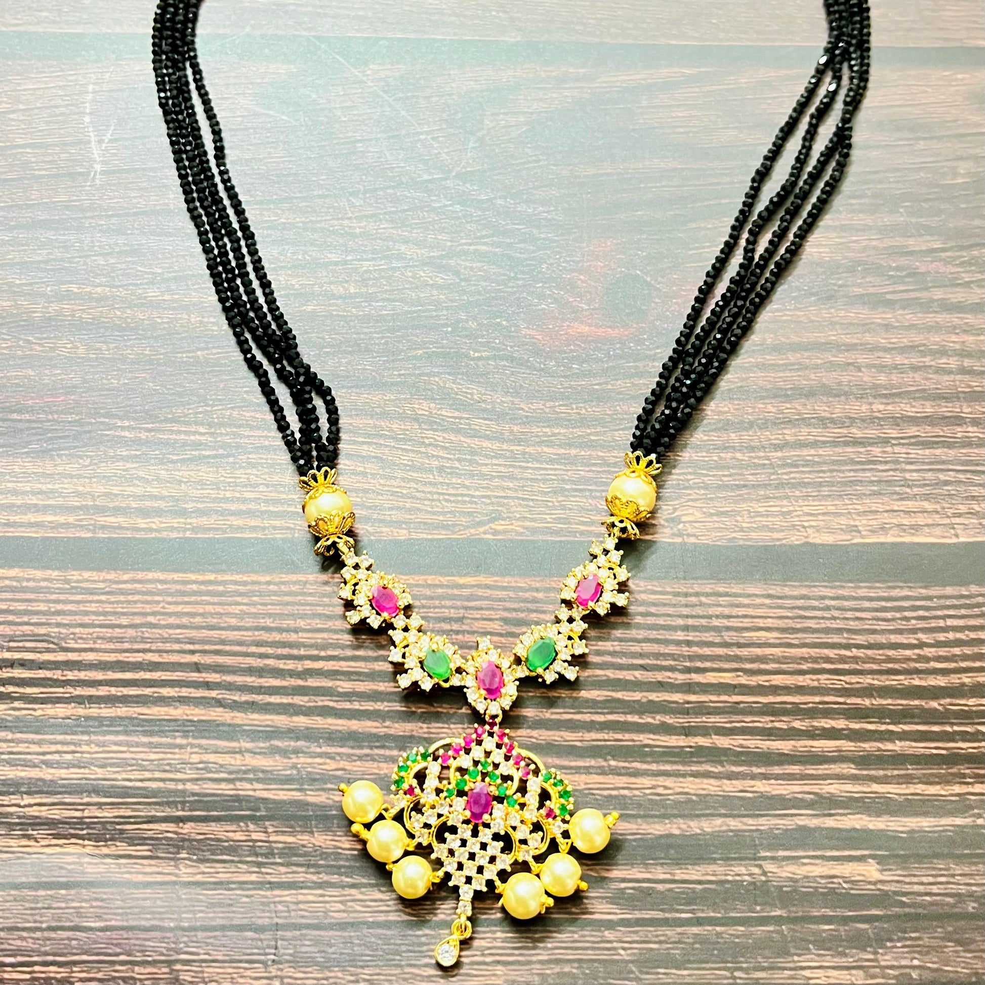 mangalsutra, bridal mangalsutra, pearl jewelry, traditional jewelry, gold plated, black beads necklace, Indian wedding, gemstone jewelry, emerald necklace, ruby necklace, designer mangalsutra, ethnic jewelry, south Indian jewelry, bridal accessories, handmade jewelry, temple jewelry, marriage mangalsutra, gold jewelry, multi-strand mangalsutra, heritage jewelry, festive jewelry, Indian bride, statement necklace, antique style, classic mangalsutra