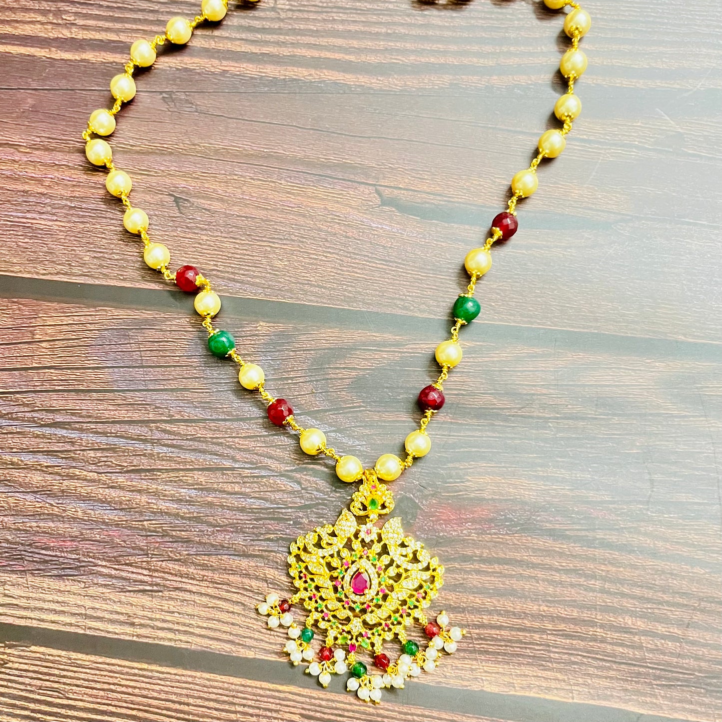 traditional necklace, temple jewelry, Indian bridal jewelry, handmade necklace, festive jewelry, gold-plated pendant, statement jewelry, pearl necklace, ruby green necklace, ethnic jewelry, South Indian jewelry, kundan choker, designer necklace, party wear jewelry, bridal set, imitation jewelry, boutique collection, ethnic wear look, wedding collection, elegant Indian necklace