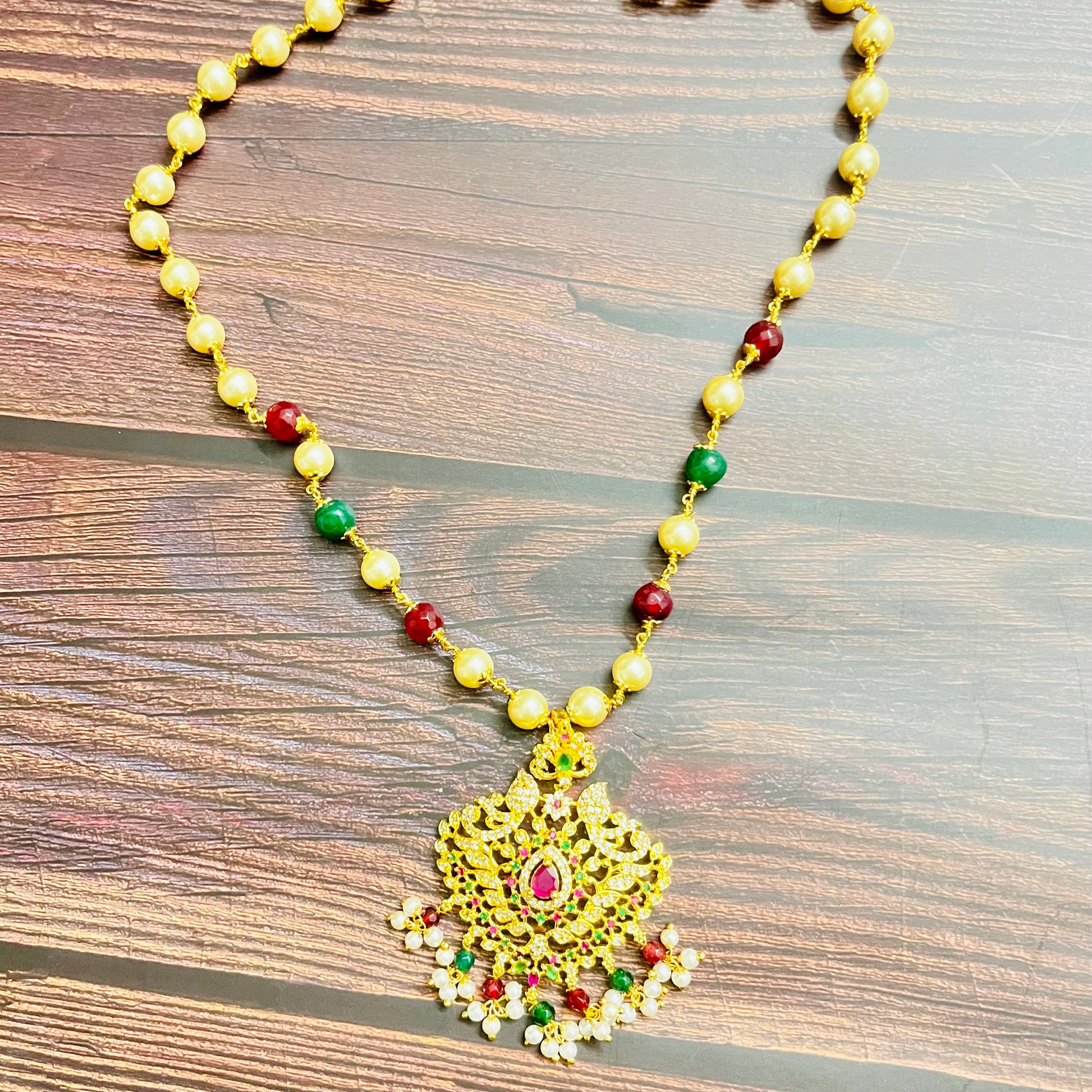 traditional necklace, temple jewelry, Indian bridal jewelry, handmade necklace, festive jewelry, gold-plated pendant, statement jewelry, pearl necklace, ruby green necklace, ethnic jewelry, South Indian jewelry, kundan choker, designer necklace, party wear jewelry, bridal set, imitation jewelry, boutique collection, ethnic wear look, wedding collection, elegant Indian necklace