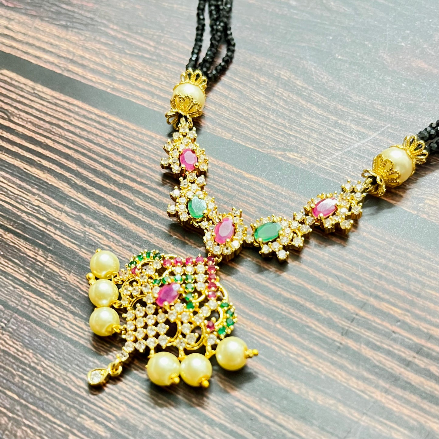 mangalsutra, bridal mangalsutra, pearl jewelry, traditional jewelry, gold plated, black beads necklace, Indian wedding, gemstone jewelry, emerald necklace, ruby necklace, designer mangalsutra, ethnic jewelry, south Indian jewelry, bridal accessories, handmade jewelry, temple jewelry, marriage mangalsutra, gold jewelry, multi-strand mangalsutra, heritage jewelry, festive jewelry, Indian bride, statement necklace, antique style, classic mangalsutra