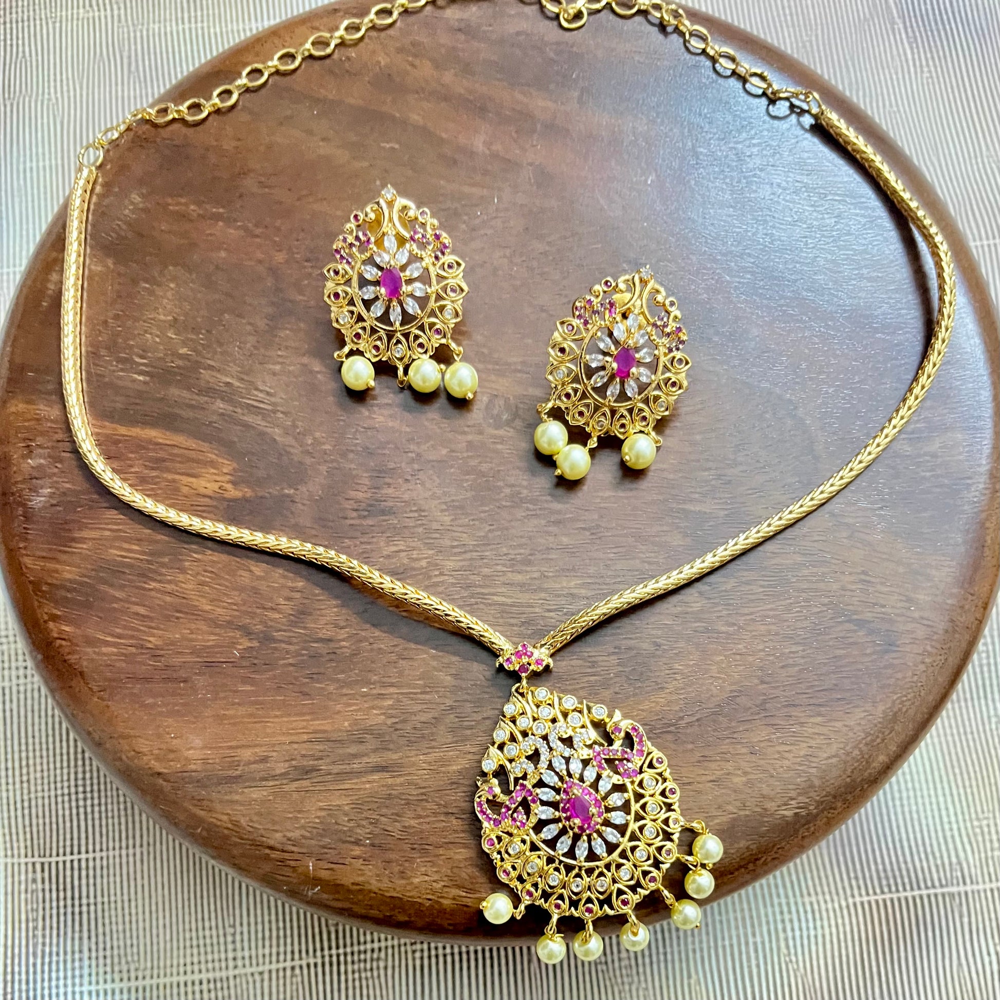 gold-plated jewelry set, necklace and earring set, traditional Indian jewelry, ruby stone necklace, pearl drop earrings, bridal jewelry set, ethnic jewelry, wedding jewelry, festive jewelry, antique finish necklace, Indian necklace set, kundan style jewelry, temple jewelry set, handcrafted jewelry, party wear necklace, designer jewelry set, red and gold jewelry, floral design necklace, imitation jewelry set, ethnic wear accessories