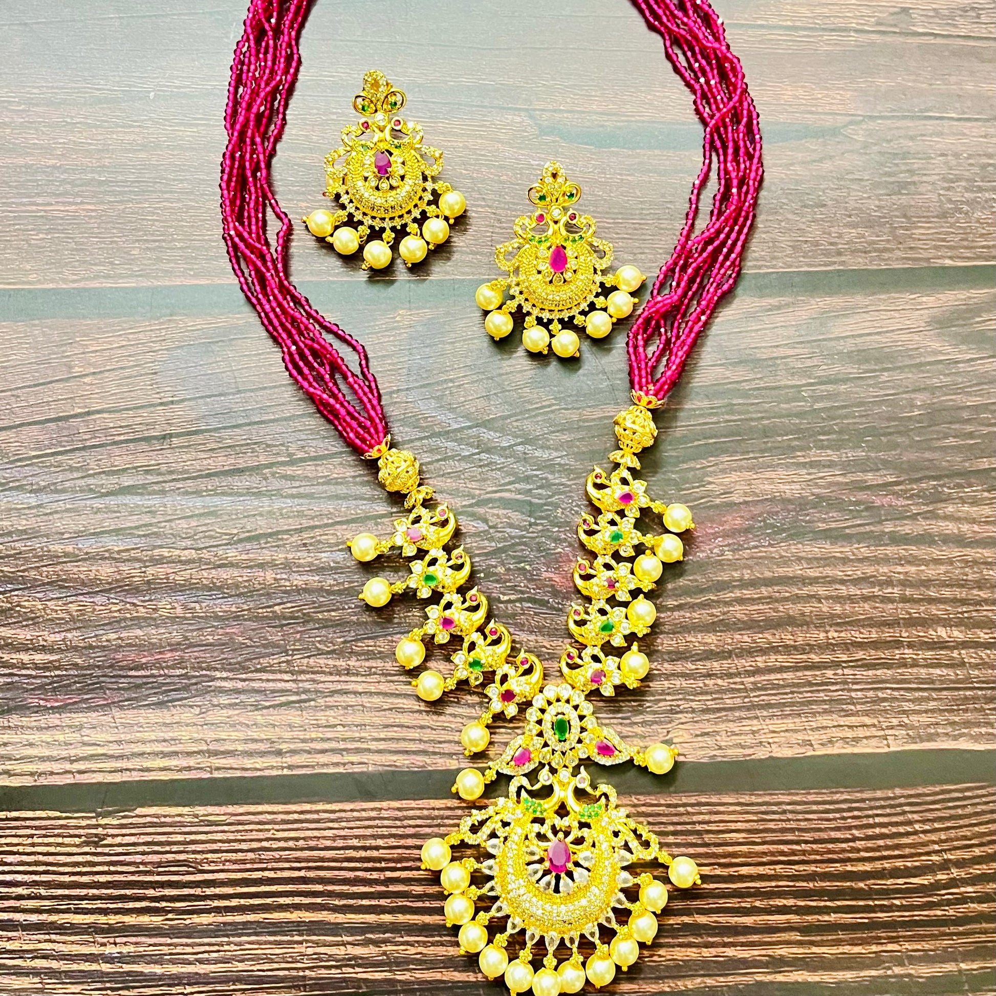 traditional jewelry, temple jewelry, bridal necklace, pearl necklace, ethnic wear, gold plated jewelry, South Indian jewelry, handcrafted jewelry, festive wear, statement necklace, antique finish, Indian bride, designer jewelry, heavy necklace set, wedding collection, navratna stones, ruby emerald combo, temple earrings, kundan work, goddess jewelry, mangalsutra look, cultural heritage, pink thread necklace, handmade jewelry, fashion accessories
