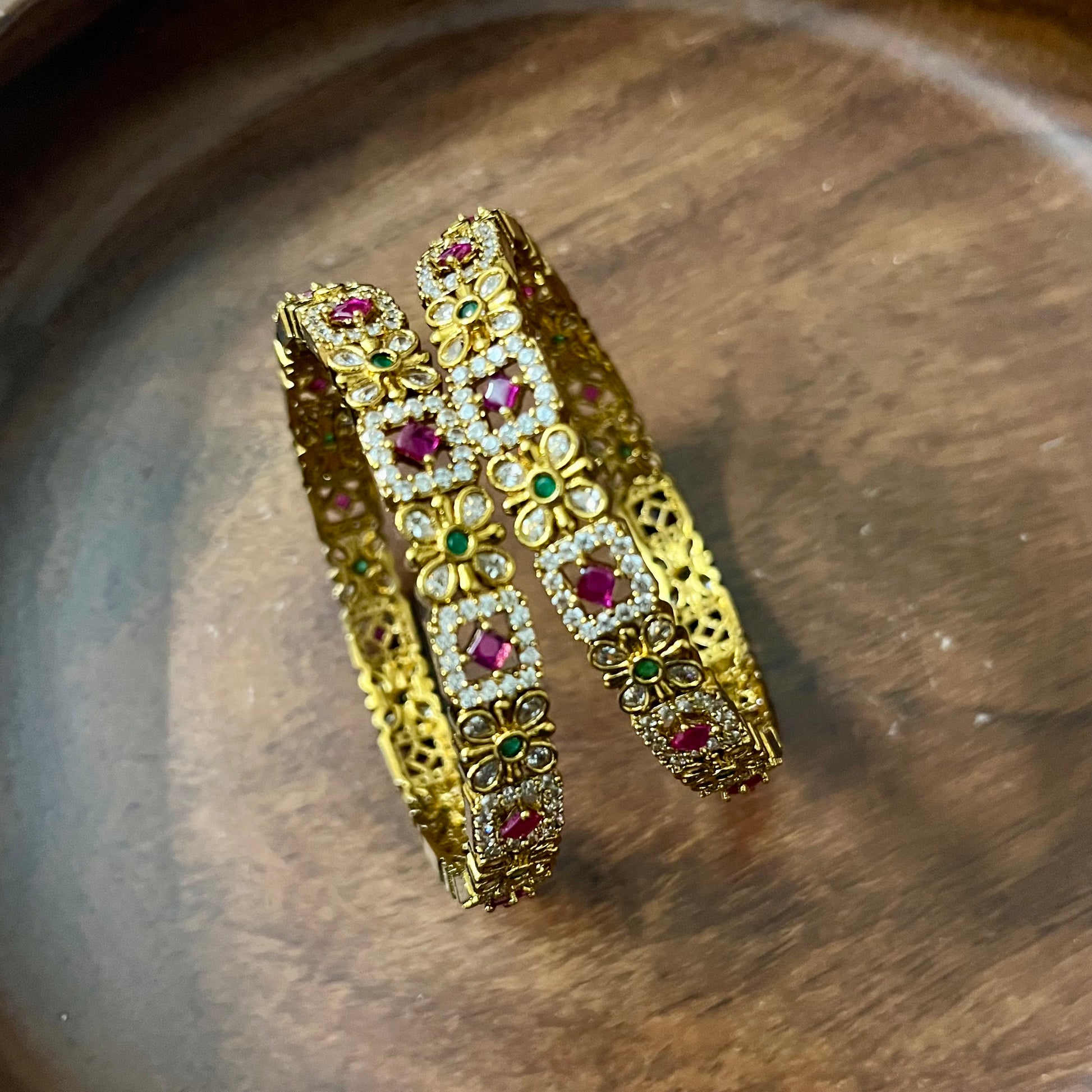 floral bangles, gold tone bangles, ruby stone bangles, emerald bangles, traditional bangles, Indian bangles, designer bangles, festive jewelry, wedding bangles, bridal bangles, ethnic jewelry, imitation bangles, kundan style bangles, party wear bangles, temple jewelry, handmade bangles, statement bangles, pushpa valli bangles, Indian accessories, South Indian jewelry