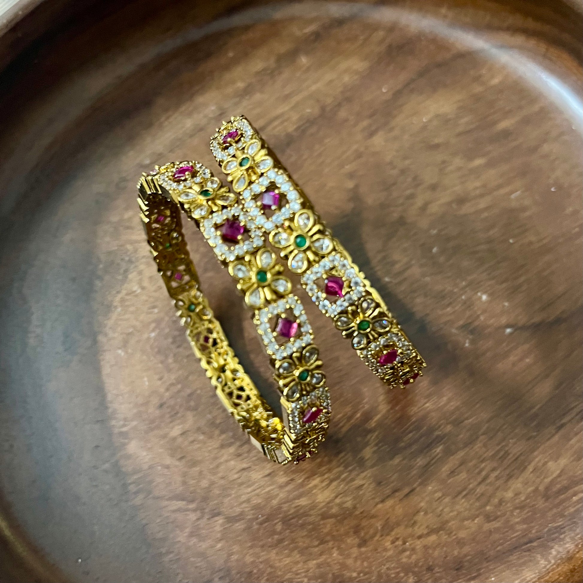 floral bangles, gold tone bangles, ruby stone bangles, emerald bangles, traditional bangles, Indian bangles, designer bangles, festive jewelry, wedding bangles, bridal bangles, ethnic jewelry, imitation bangles, kundan style bangles, party wear bangles, temple jewelry, handmade bangles, statement bangles, pushpa valli bangles, Indian accessories, South Indian jewelry