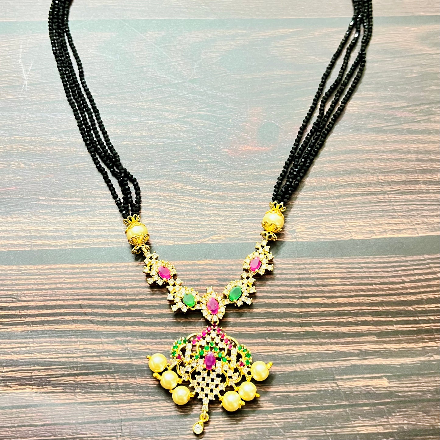 mangalsutra, bridal mangalsutra, pearl jewelry, traditional jewelry, gold plated, black beads necklace, Indian wedding, gemstone jewelry, emerald necklace, ruby necklace, designer mangalsutra, ethnic jewelry, south Indian jewelry, bridal accessories, handmade jewelry, temple jewelry, marriage mangalsutra, gold jewelry, multi-strand mangalsutra, heritage jewelry, festive jewelry, Indian bride, statement necklace, antique style, classic mangalsutra