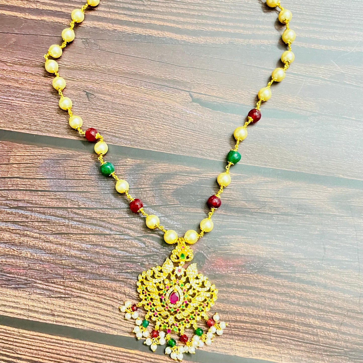 traditional necklace, temple jewelry, Indian bridal jewelry, handmade necklace, festive jewelry, gold-plated pendant, statement jewelry, pearl necklace, ruby green necklace, ethnic jewelry, South Indian jewelry, kundan choker, designer necklace, party wear jewelry, bridal set, imitation jewelry, boutique collection, ethnic wear look, wedding collection, elegant Indian necklace