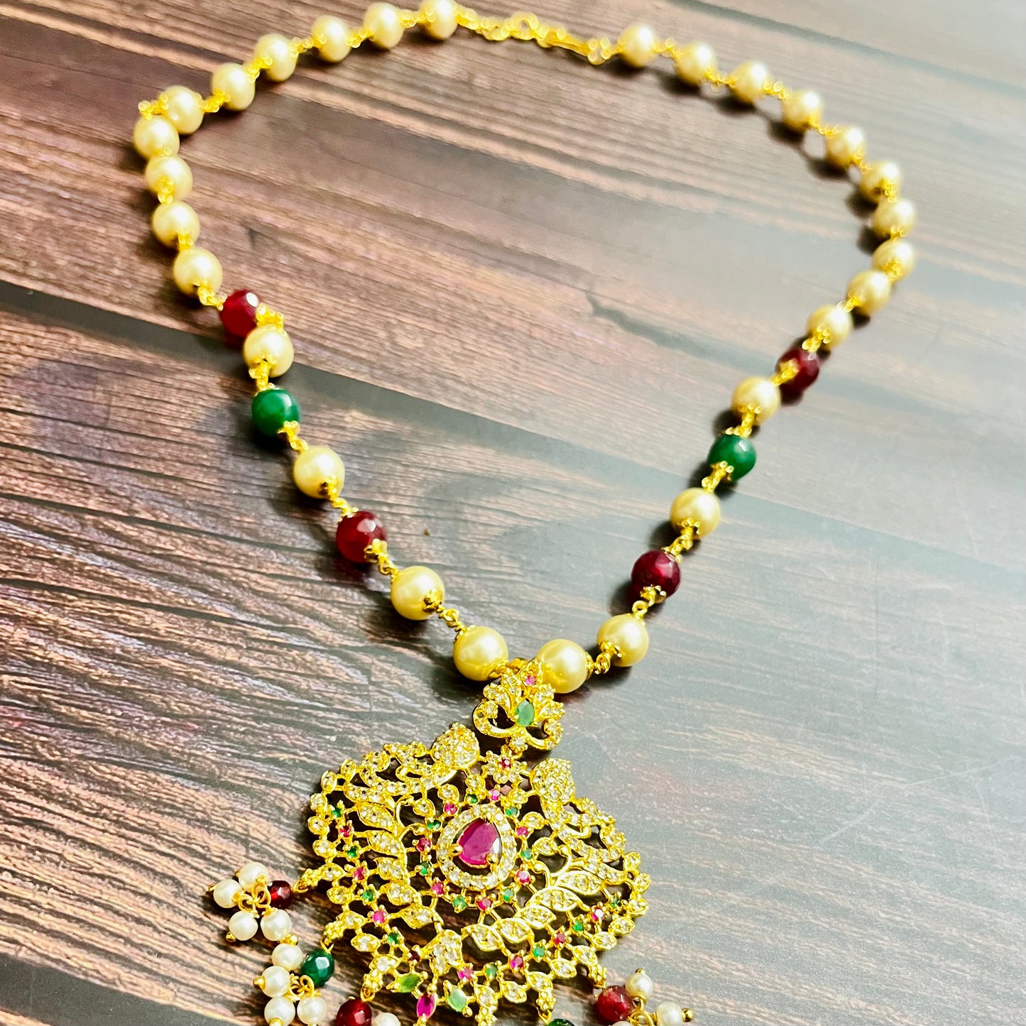 traditional necklace, temple jewelry, Indian bridal jewelry, handmade necklace, festive jewelry, gold-plated pendant, statement jewelry, pearl necklace, ruby green necklace, ethnic jewelry, South Indian jewelry, kundan choker, designer necklace, party wear jewelry, bridal set, imitation jewelry, boutique collection, ethnic wear look, wedding collection, elegant Indian necklace