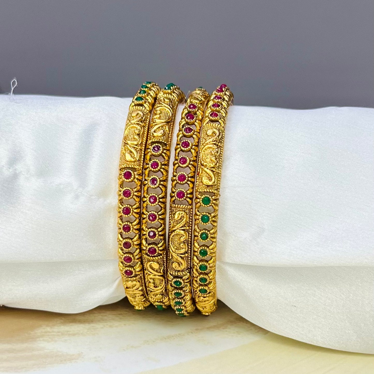 designer imitation bangles, red and green stone bangles, traditional jewelry, ethnic bangles, handmade bangles, Indian jewelry, imitation bangles online, festive accessories, handcrafted jewelry, stylish bangles, wedding jewelry, ethnic wear accessories, Matsya Boutique bangles, jewelry for women, designer jewelry