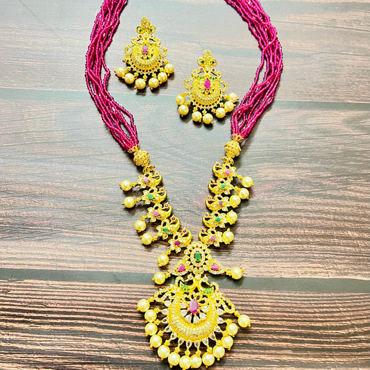traditional jewelry, temple jewelry, bridal necklace, pearl necklace, ethnic wear, gold plated jewelry, South Indian jewelry, handcrafted jewelry, festive wear, statement necklace, antique finish, Indian bride, designer jewelry, heavy necklace set, wedding collection, navratna stones, ruby emerald combo, temple earrings, kundan work, goddess jewelry, mangalsutra look, cultural heritage, pink thread necklace, handmade jewelry, fashion accessories