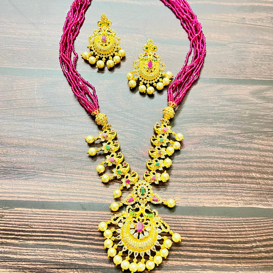 traditional jewelry, temple jewelry, bridal necklace, pearl necklace, ethnic wear, gold plated jewelry, South Indian jewelry, handcrafted jewelry, festive wear, statement necklace, antique finish, Indian bride, designer jewelry, heavy necklace set, wedding collection, navratna stones, ruby emerald combo, temple earrings, kundan work, goddess jewelry, mangalsutra look, cultural heritage, pink thread necklace, handmade jewelry, fashion accessories