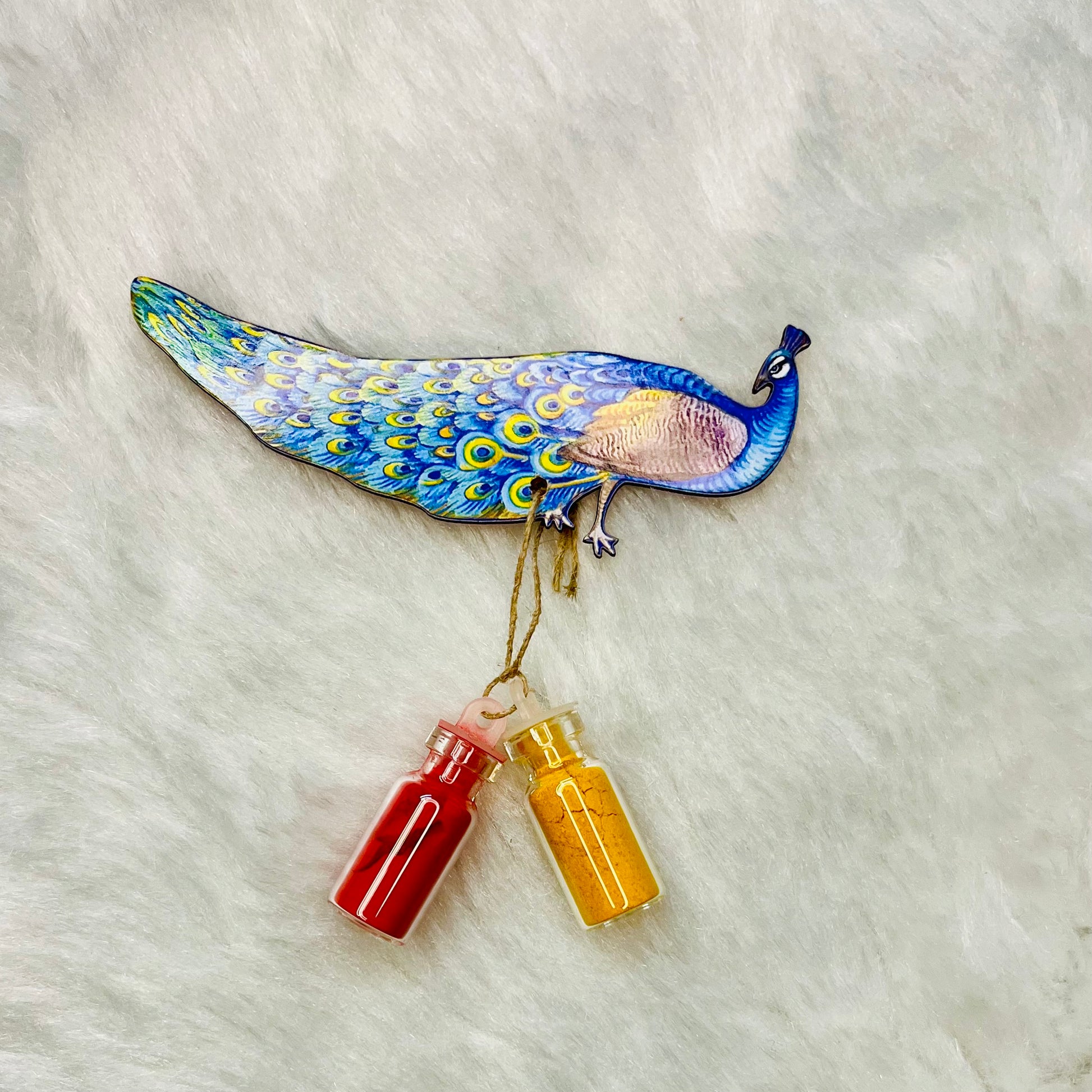 Vibrant Pichwai-style peacock Haldi Kumkum holder, depicting a detailed blue and green peacock with two glass bottles of turmeric (haldi) and vermillion (kumkum), ideal for traditional Indian rituals and ceremonies.

Pichwai peacock Haldi Kumkum holder, Indian Haldi Kumkum decor, traditional Indian ceremony accessory, colorful Pichwai art, Hindu ritual essentials.